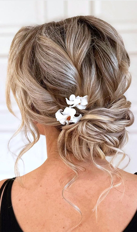 35 Enchanting Hairstyles for a Fairytale Wedding : Messy Low Bun with Floral Hair Pin