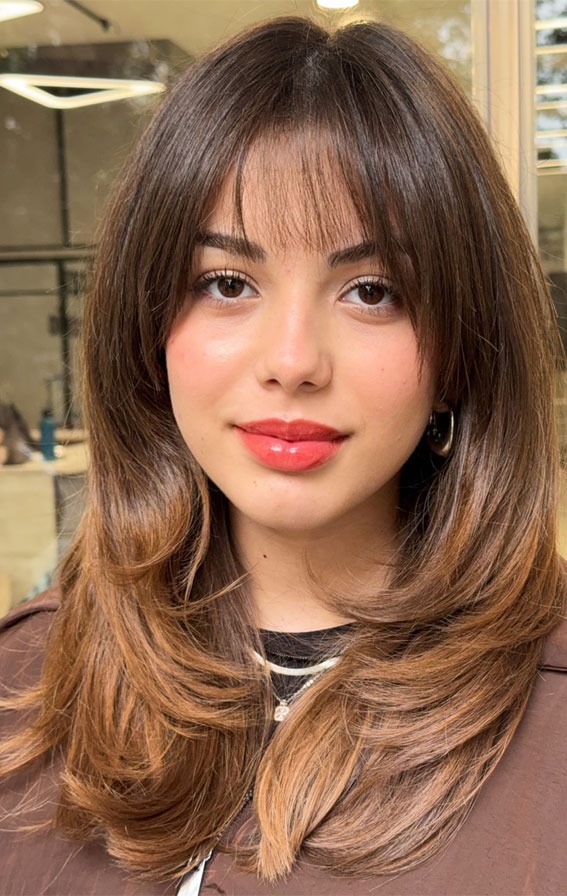 30 Hottest Hair Colours to Try This Winter : Subtle Caramel Layers with Wispy Curtain Bangs