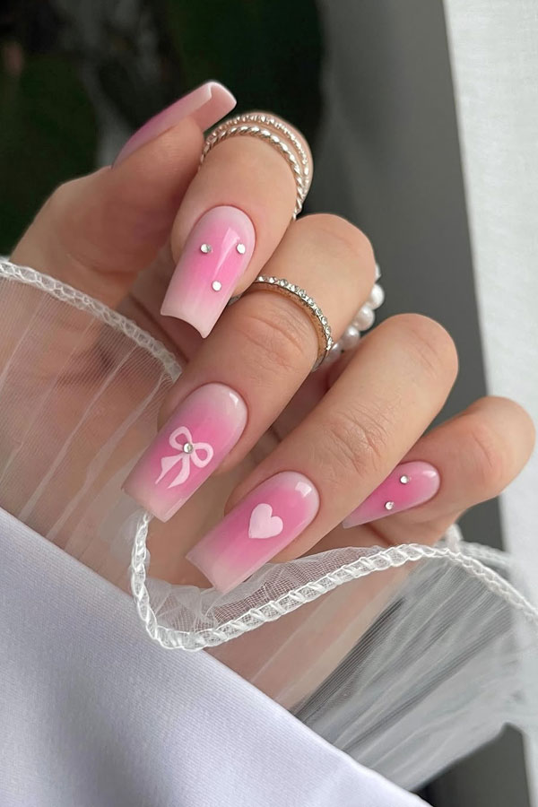 36 Cute Valentine’s Day Nails : Delicate Pink Aura Nails with Bows and Hearts